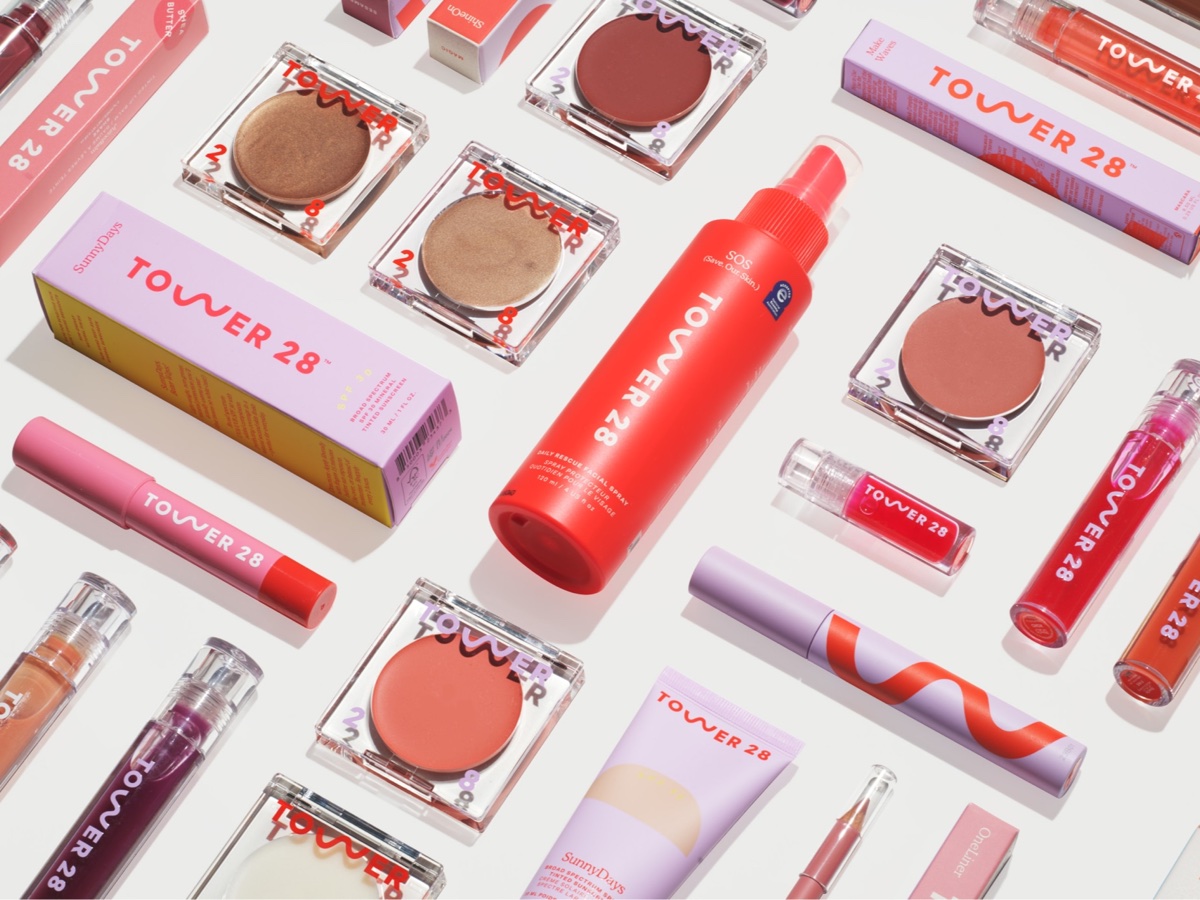 Productos de belleza y cuidado personal ordenados sobre un fondo rosa