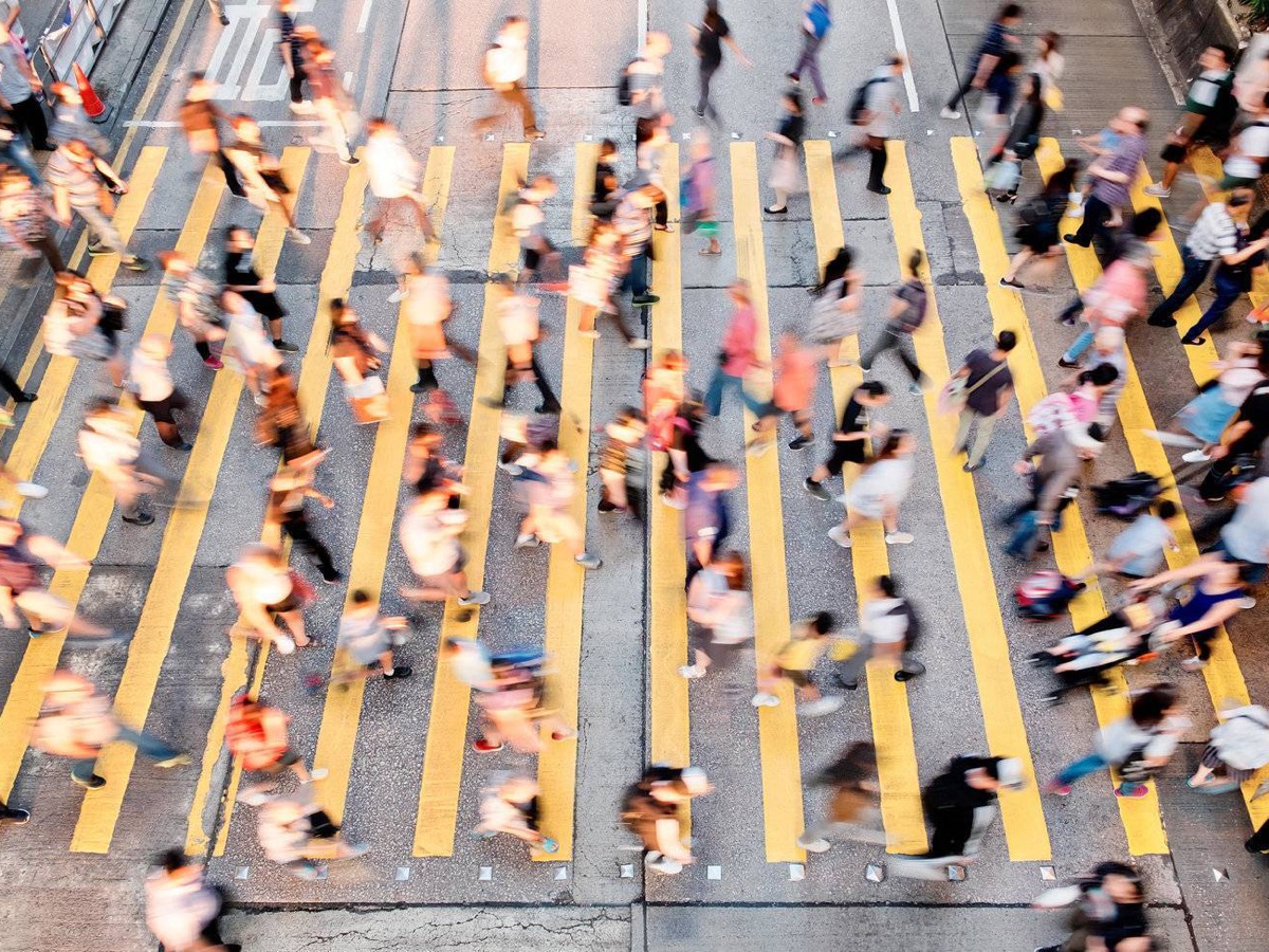 Vista aérea de una multitud cruzando una avenida en una gran ciudad